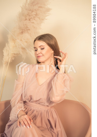 girl in pastel-colored dress sits on chair and looks away 89984188