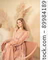 girl in pastel-colored dress sits on chair and looks away 89984189