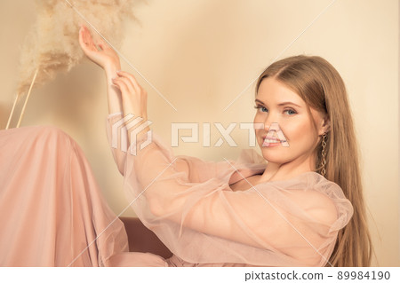girl in pastel-colored dress sits on chair with her legs up girl in pastel-colored dress sits on chair with her legs up 89984190