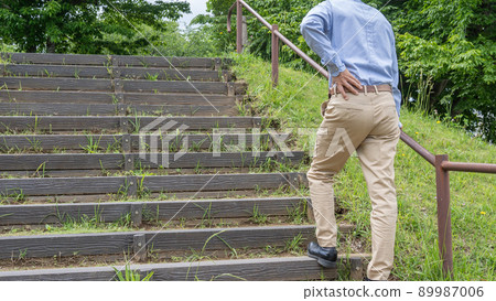 一個男人在樓梯上呼吸急促和背痛的形象 89987006