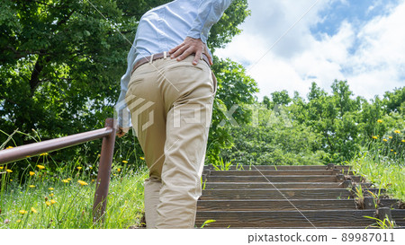 Image of a man with shortness of breath and back pain on the stairs Image of a man with shortness of breath and back pain on the stairs 89987011