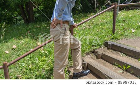 Image of a man with shortness of breath and back pain on the stairs 89987015