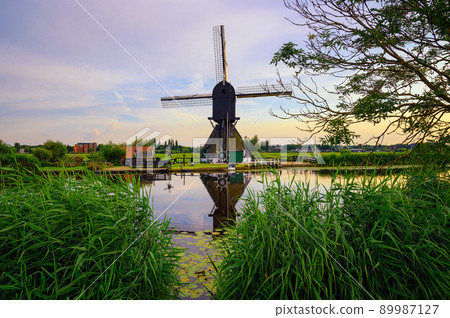 Old dutch windmill at sunset in Kinderdijk, Netherlands 89987127