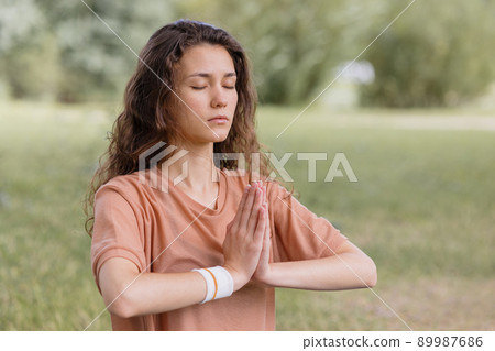 woman with curly hair meditates in a park. yoga and meditation for mental and physical health woman with curly hair meditates in a park. yoga and meditation for mental and physical health 89987686