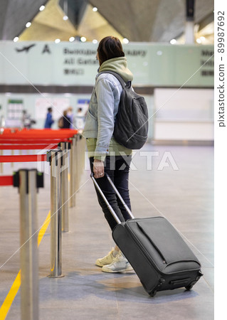 European woman at the airport waiting to board her flight, flight and boarding delays 89987692