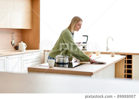 Young woman puts plates on kitchen table at home Young woman puts plates on kitchen table at home 89988007