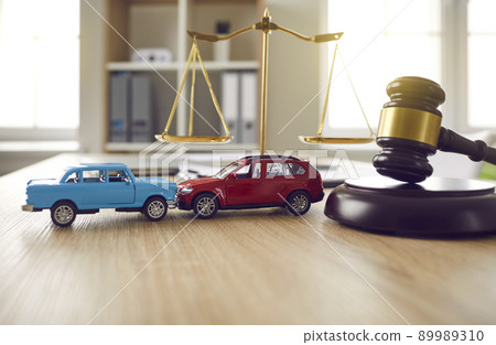 Gavel and two crashed toy cars on lawyer's or judge's table illustrating car insurance concept Gavel and two crashed toy cars on lawyer's or judge's table illustrating car insurance concept 89989310