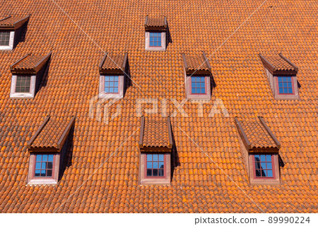 Many small windows on a red roof covered with tiles in the old town of Gdansk Many small windows on a red roof covered with tiles in the old town of Gdansk 89990224
