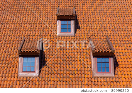 Many small windows on a red roof covered with tiles in the old town of Gdansk 89990230