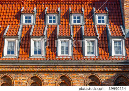 Many small windows on a red roof covered with tiles in the old town of Gdansk Many small windows on a red roof covered with tiles in the old town of Gdansk 89990234