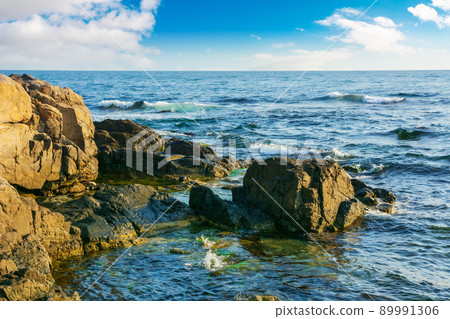 stones and rock at the sea. beautiful nature background with calm water in morning light stones and rock at the sea. beautiful nature background with calm water in morning light 89991306