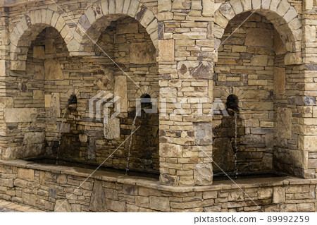 street drinking fountain in a natural stone arch street drinking fountain in a natural stone arch 89992259