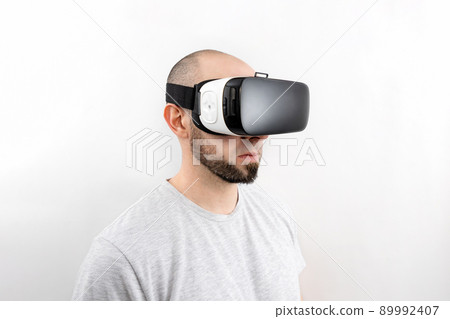 Portrait of a Caucasian man in VR glasses on a white background. The concept of virtual reality and modern entertainment 89992407