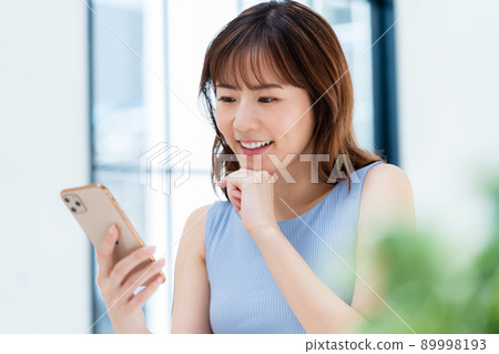 Woman operating a smartphone Woman operating a smartphone 89998193