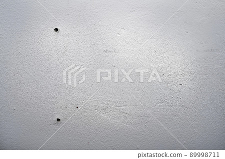 Hole and dowels in an old dirty white wall. 89998711