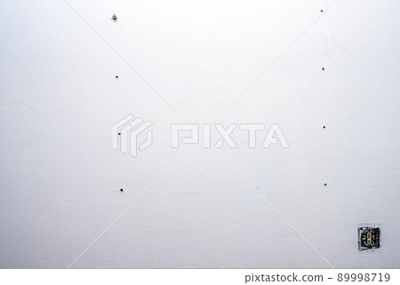 Hole and dowels in an old dirty white wall. 89998719