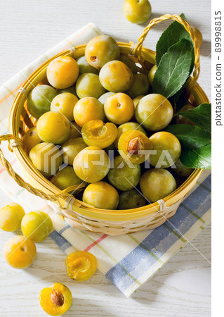 Berries yellow plums on a white wooden table 89998815