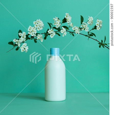 Bottle for cosmetic products without a label with a flower branch. Facial skin care concept 90001597