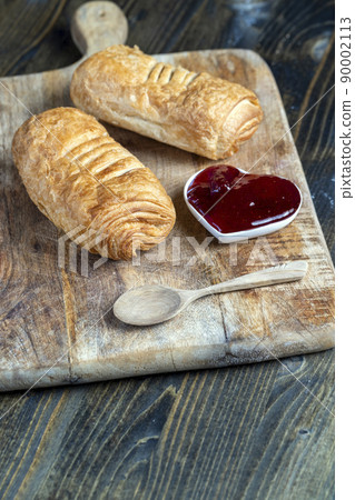 puff pastry with red strawberry jam on a wooden table puff pastry with red strawberry jam on a wooden table 90002113