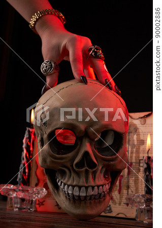 Vertical shot hand over the humans skull on black background. 90002886