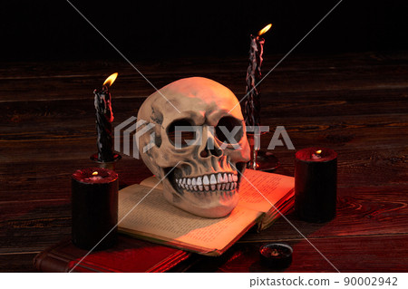 Halloween composition of spooky humans skull with burning candles. 90002942