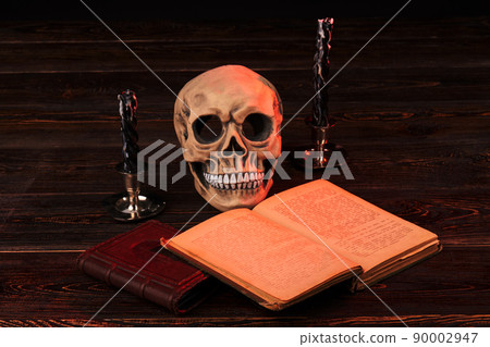 Satanism religion concept. Human skull with extinguished candles. 90002947