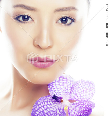 young pretty asian woman with flower purple orchid close up isolated on white background spa smiling casual 90003004