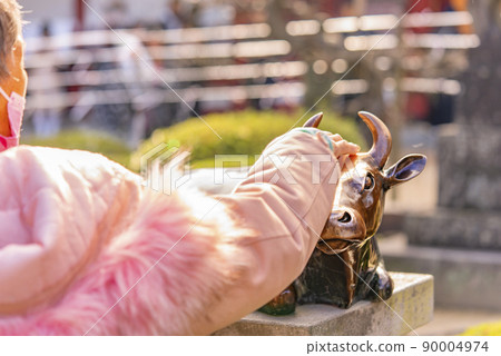[Kyushu / Dazaifu] A close-up of the hands of worshipers stroking the statue of Ox at Dazaifu Tenmangu Shrine. 90004974