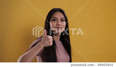 Young pretty woman makes thumb-up gesture 90005642