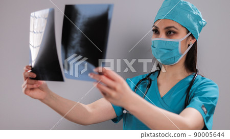 Female Doctor at hospital looks at X-rays Female Doctor at hospital looks at X-rays 90005644