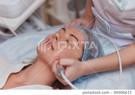 LED light anti-aging mask for facial skin care in a spa slow motion. A woman lies on a couch in a special mask. Modern technologies of beauty and health. LED light anti-aging mask for facial skin care in a spa slow motion. A woman lies on a couch in a special mask. Modern technologies of beauty and health. 90006615