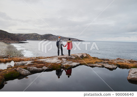 Senior couple standing overlooking an ice-covered. Senior couple standing overlooking an ice-covered. 90006640