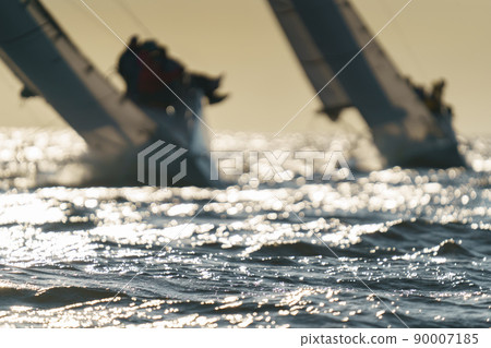 Teamwork in sailing regatta at sunset, still water, the clear sky, hot racing Teamwork in sailing regatta at sunset, still water, the clear sky, hot racing 90007185