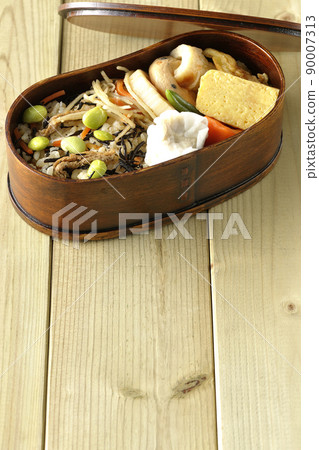 Makunouchi lunch box with lots of side dishes such as hijiki and edamame rice, shumai, omelet, and simmered dishes Makunouchi lunch box with lots of side dishes such as hijiki and edamame rice, shumai, omelet, and simmered dishes 90007313