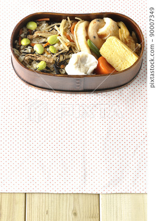 Makunouchi午餐盒的鳥瞰圖，裡面有很多小菜，如羊栖菜和毛豆飯、燒麥、煎蛋捲和燉菜。 90007349