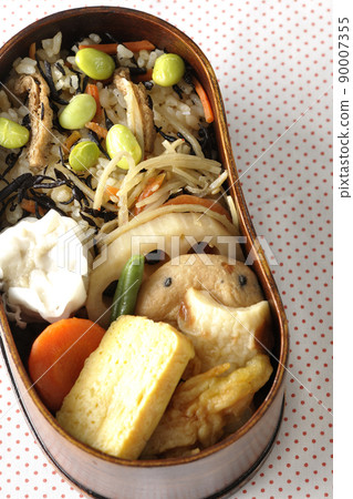 Makunouchi午餐盒的鳥瞰圖，裡面有很多小菜，如羊栖菜和毛豆飯、燒麥、煎蛋捲和燉菜。 90007355