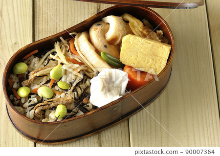 Makunouchi午餐盒的鳥瞰圖，裡面有很多小菜，如羊栖菜和毛豆飯、燒麥、煎蛋捲和燉菜。 90007364