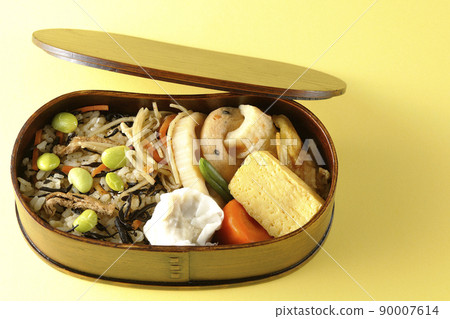 A bird's-eye view of the Makunouchi lunch box containing a lot of side dishes such as hijiki and edamame rice, shumai, omelet, and simmered dishes. A bird's-eye view of the Makunouchi lunch box containing a lot of side dishes such as hijiki and edamame rice, shumai, omelet, and simmered dishes. 90007614