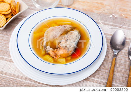 Fish broth with salmon head and vegetables served with salty crackers Fish broth with salmon head and vegetables served with salty crackers 90008200