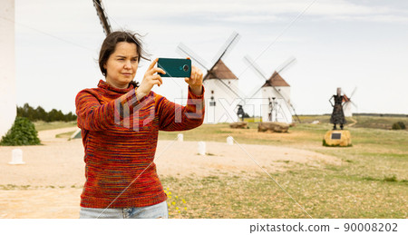 Focused woman recording video with phone in Mota del Cuervo 90008202