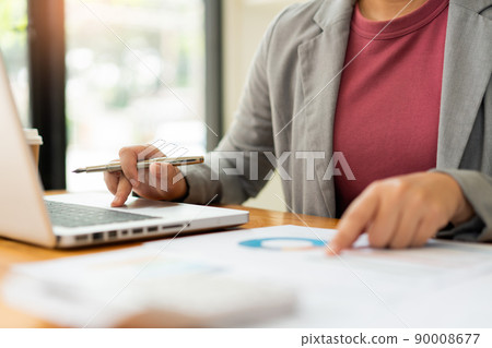 Business analyst concept the data analyst holding and pointing her pen at the document about sale chart Business analyst concept the data analyst holding and pointing her pen at the document about sale chart 90008677