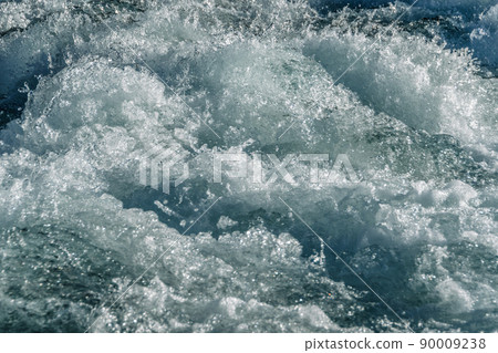 Turquoise ocean waves as backdrop. Sea water boils and foams during surf. Mountain blue river with fast current Turquoise ocean waves as backdrop. Sea water boils and foams during surf. Mountain blue river with fast current 90009238
