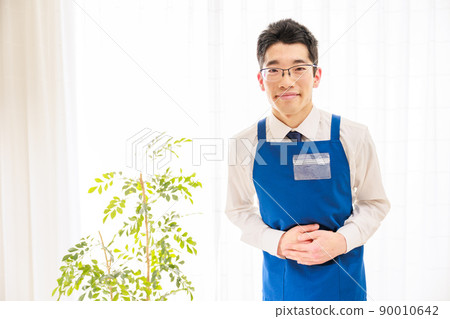 穿著藍色圍裙微笑的亞洲男職員 90010642