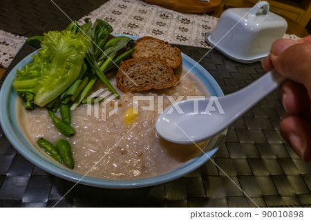 Congee, soft boiled rice with ginkgo and vegetables, chilli, Oblique view from the top. 90010898