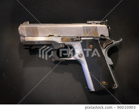 Old and dirty pistol gun on the fabric background 90010903