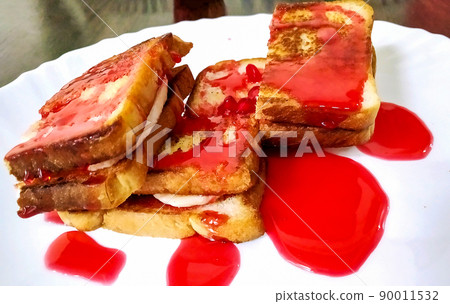 Banana toast bread with strawberry jam on a white plate Banana toast bread with strawberry jam on a white plate 90011532