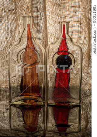 Still life with glass objects on a background of burlap 90011995
