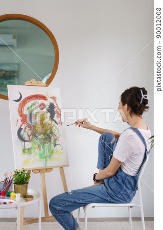 Creative of art concept, Young asian woman holding paintbrush and contemplate about the artwork Creative of art concept, Young asian woman holding paintbrush and contemplate about the artwork 90012008