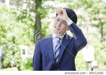 A businessman working outdoors on a midsummer day 90012686