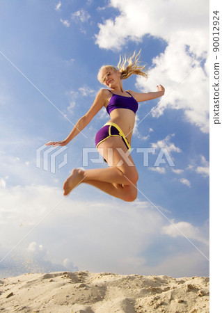 Young woman playing the sand. 90012924